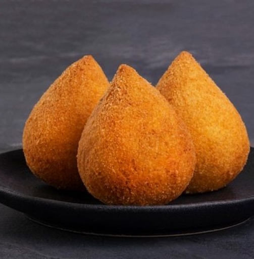 Coxinha frita tradicional em uma placa preta sobre fundo de ardósia - petisco brasileiro_ _ Foto Premium